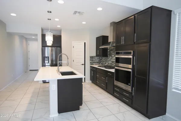 a kitchen with stainless steel appliances kitchen island granite countertop a refrigerator and a stove top oven