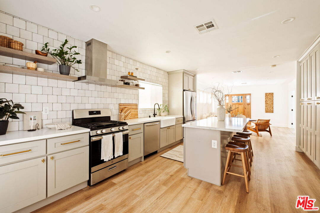 2831 South Corning Street Los Angeles, CA 90034 - Photo 17 of 41 a kitchen with a sink appliances cabinets and wooden floor