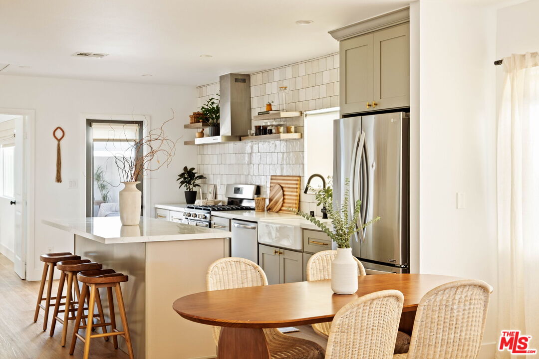 2831 South Corning Street Los Angeles, CA 90034 - Photo 10 of 41 a kitchen with stainless steel appliances granite countertop a dining table and chairs