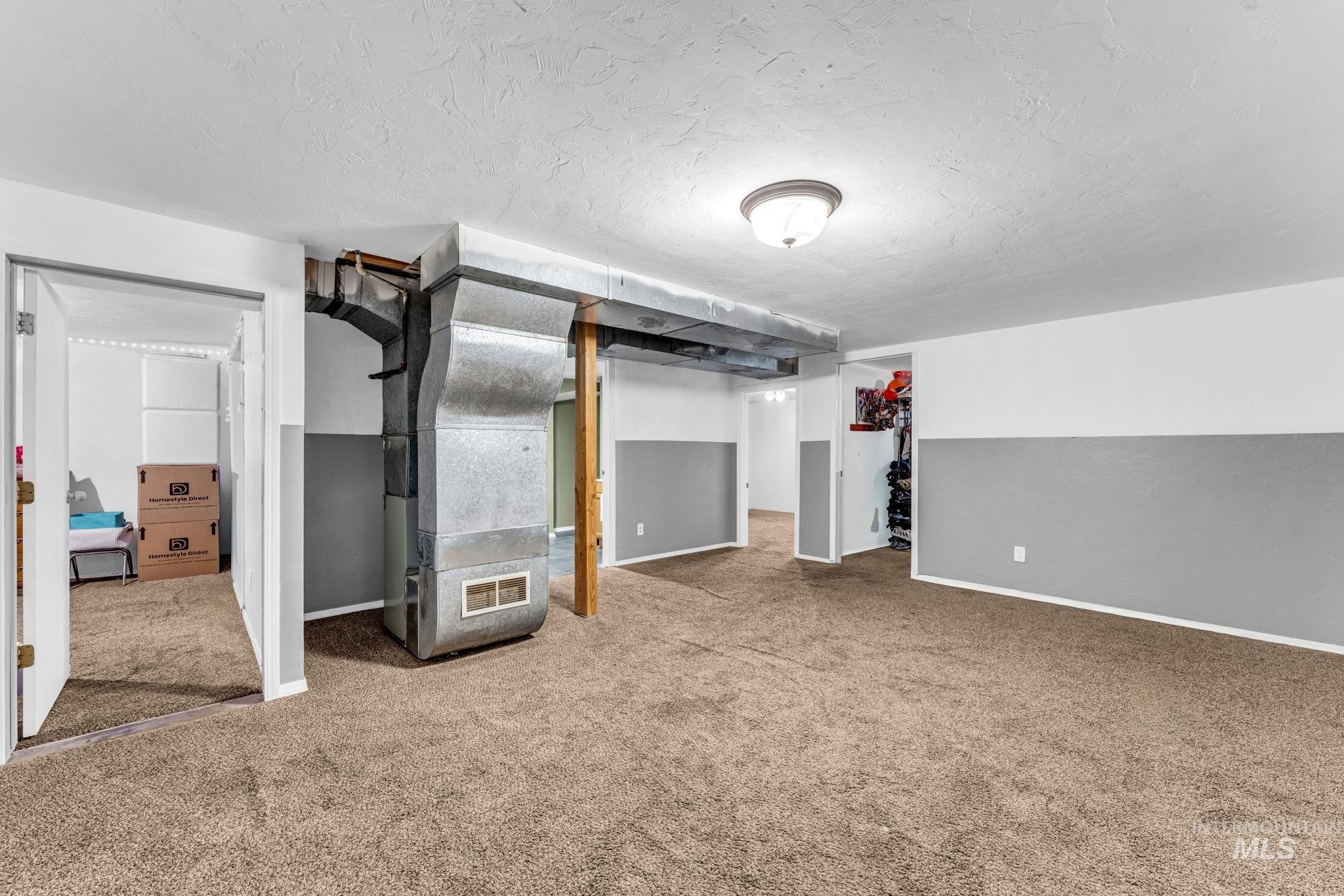 820 Meadows Drive Twin Falls, ID 83301 - Photo 22 of 38 Carpeted room featuring a ceiling fan with integrated lighting, a paneled door, and textured wall finishes