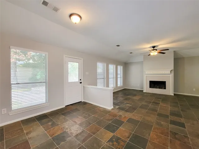 a view of an empty room with a fireplace and a window
