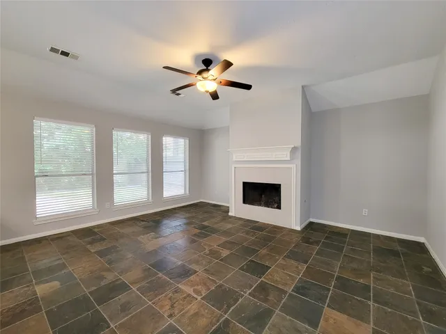 a view of an empty room with a fireplace and a window