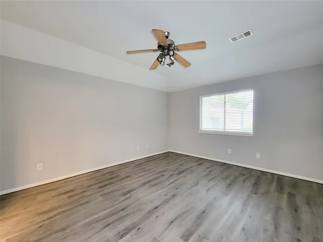 wooden floor in an empty room with a window