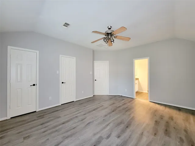 a view of room with wooden floor and ceiling fan