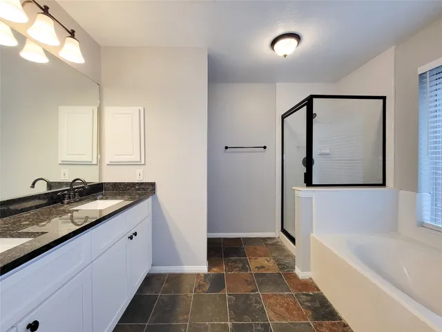 a bathroom with a granite countertop sink a toilet and bathtub