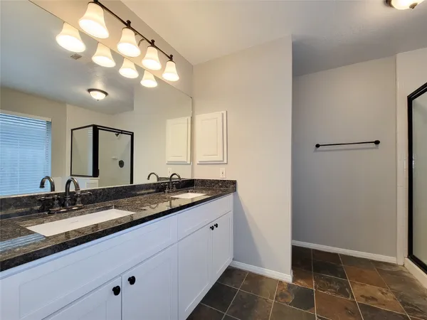 a bathroom with a granite countertop sink a toilet and a mirror