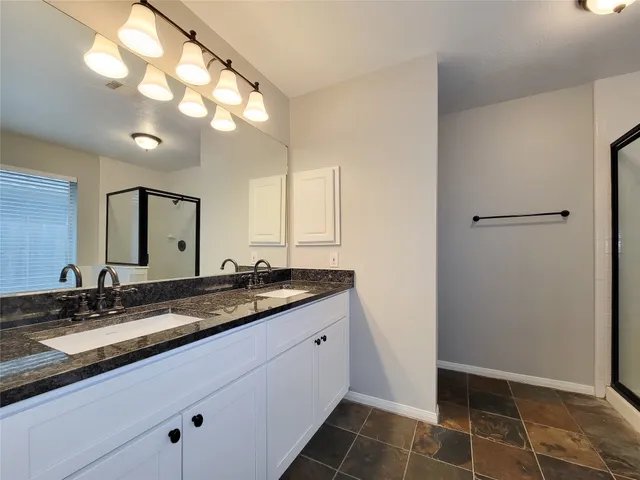 a bathroom with a granite countertop sink a toilet and a mirror