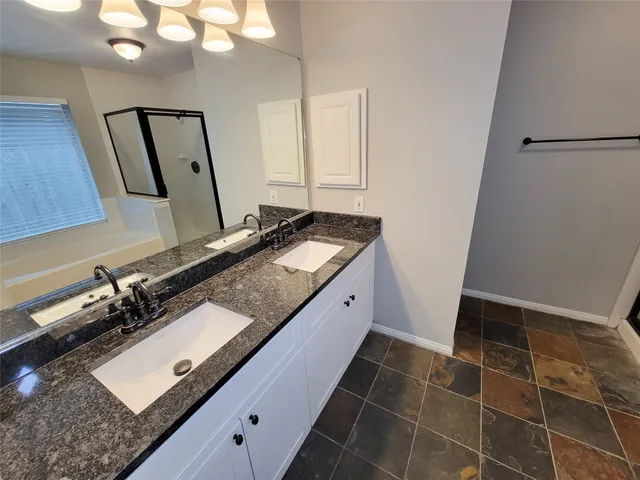 a bathroom with a granite countertop sink and a mirror