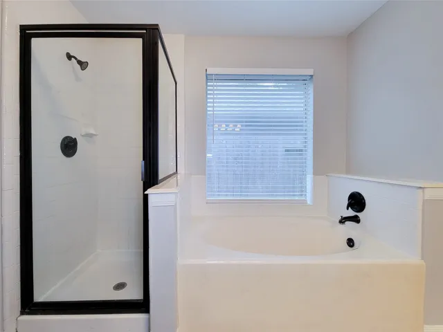 a bathroom with a bathtub and a shower