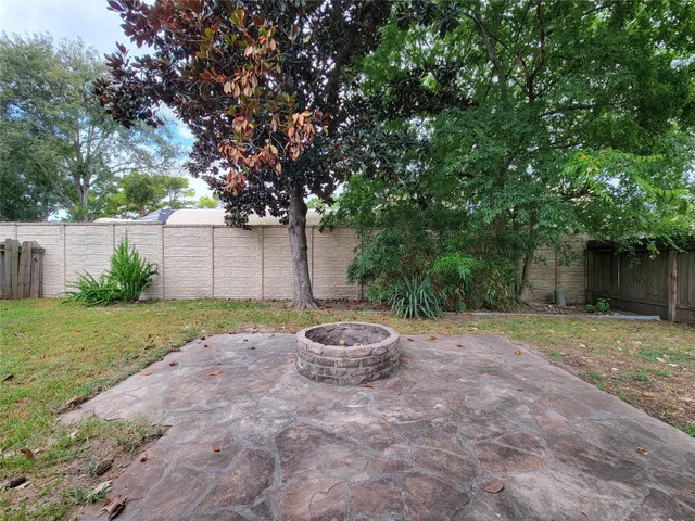 a view of a house with a yard and large tree