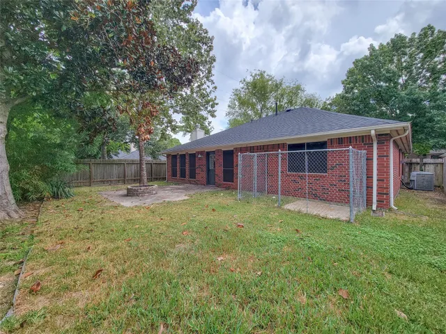 a view of a backyard with large trees and a barn