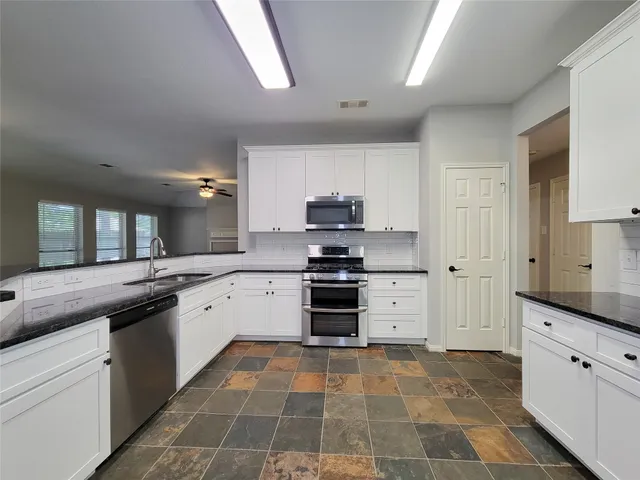 a kitchen with stainless steel appliances granite countertop a stove and a sink