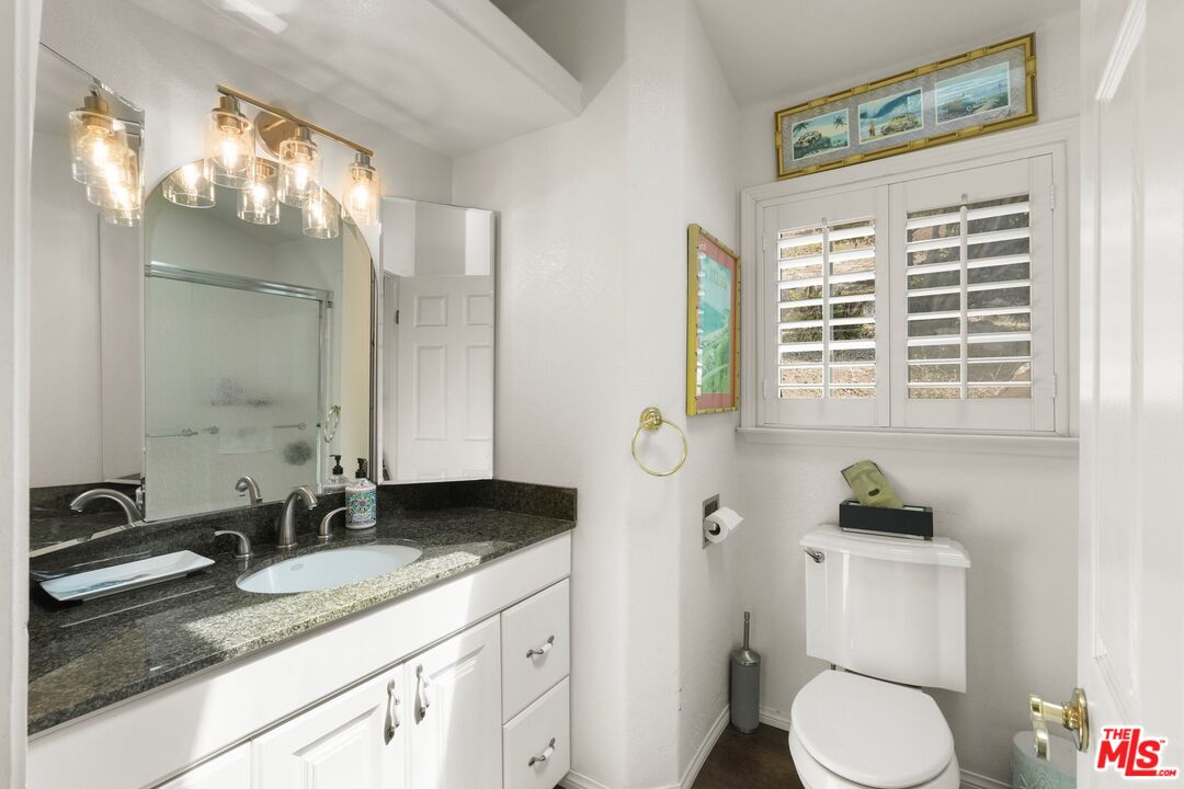 31 Paradise Cove Road Malibu, CA 90265 - Photo 19 of 27 a bathroom with a granite countertop sink toilet and mirror