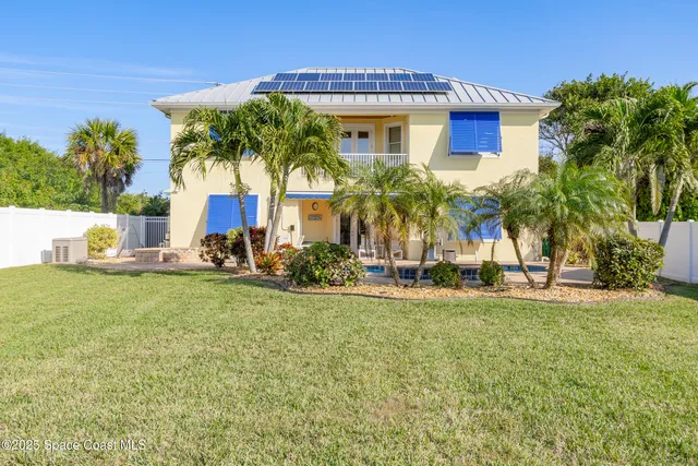 a front view of a house with a garden and yard