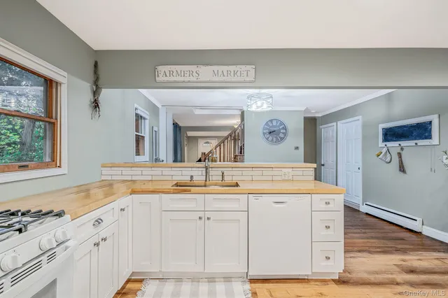 a living room with furniture a flat screen tv and floor to ceiling window