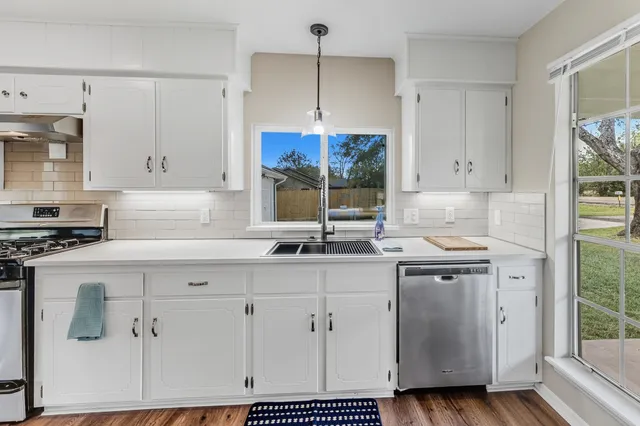 a kitchen with stainless steel appliances granite countertop a sink stove and wooden floor