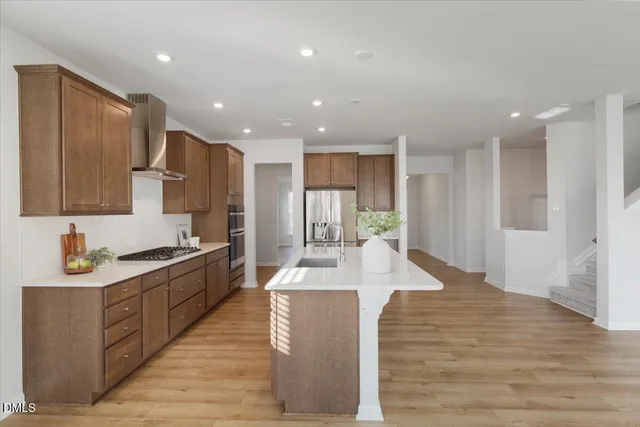 a large kitchen with kitchen island a sink stainless steel appliances and cabinets