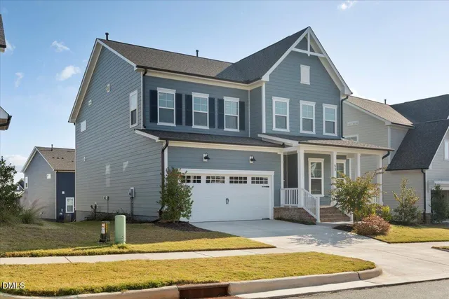 a view of a white house with large windows and a small yard