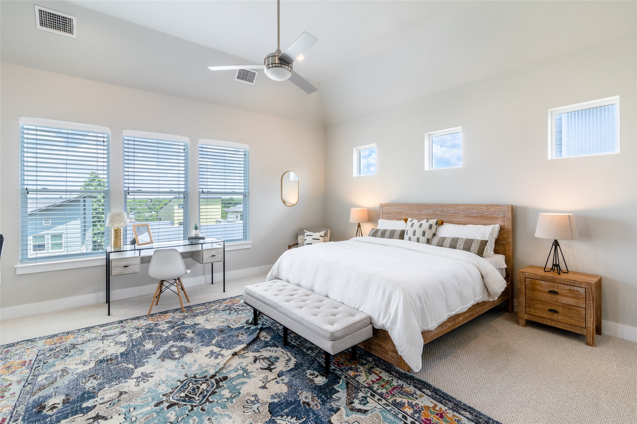 6025 Seville Drive Austin, TX 78724 - Photo 5 of 40 Second floor primary bedroom featuring high ceilings with a ceiling fan, multiple windows with natural lighting, and three transom windows