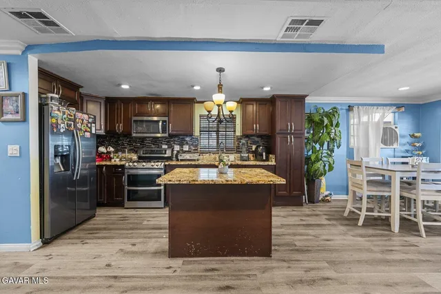 a kitchen with stainless steel appliances granite countertop a stove refrigerator sink and cabinets