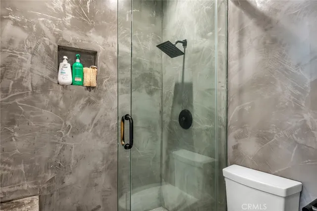 a bathroom with a toilet and a shower