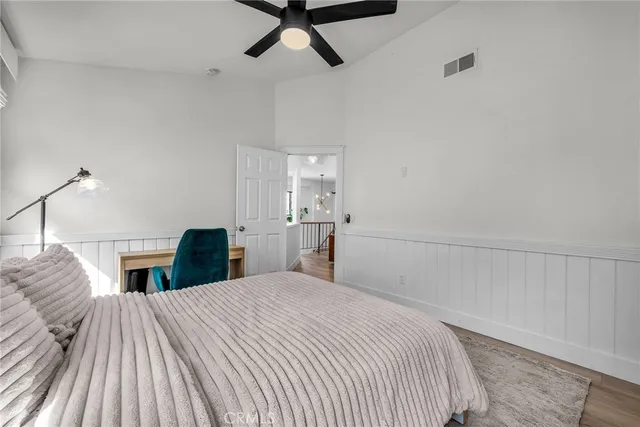 a bedroom with a bed and painting on the wall