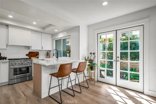 a kitchen with kitchen island a stove a cabinets a sink and a island