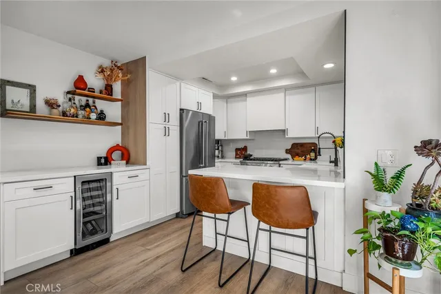 a kitchen with stainless steel appliances kitchen island granite countertop a refrigerator and a stove top oven