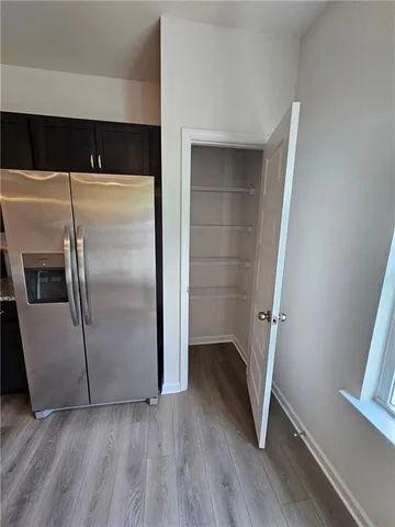 a kitchen with a refrigerator and wooden floor