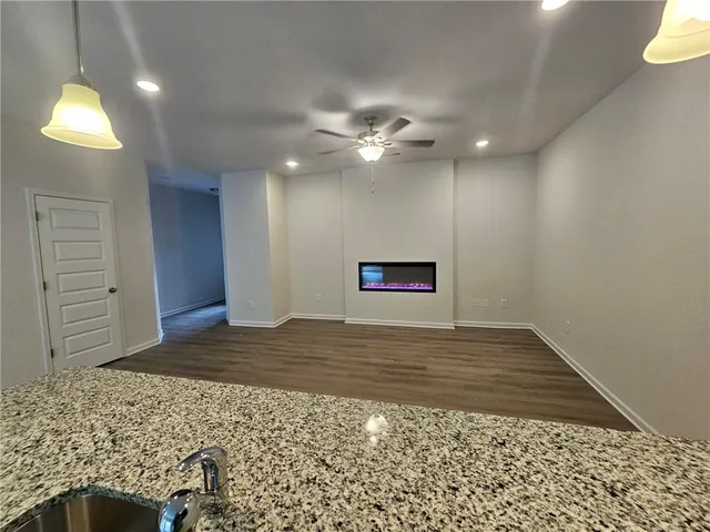 a view of a hallway with a chandelier fan and wooden floor