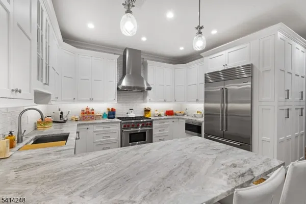 a kitchen with granite countertop a stove a sink and a refrigerator