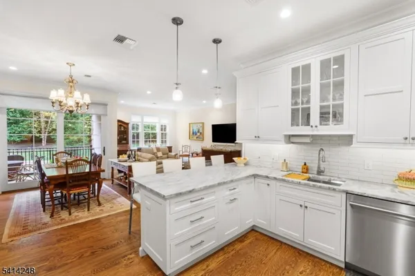 a kitchen with a sink stove and dining table with wooden floor