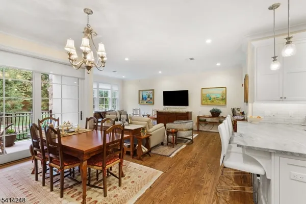 a view of a dining room and livingroom view with furniture wooden floor and a chandelier