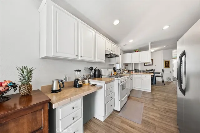 a kitchen with white cabinets and white appliances