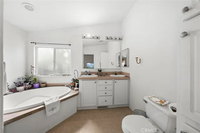 a spacious bathroom with a granite countertop sink mirror vanity and toilet