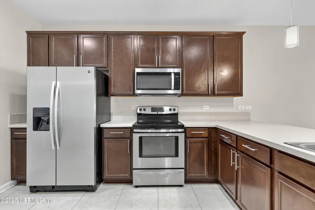 a kitchen with stainless steel appliances granite countertop a refrigerator and a stove top oven
