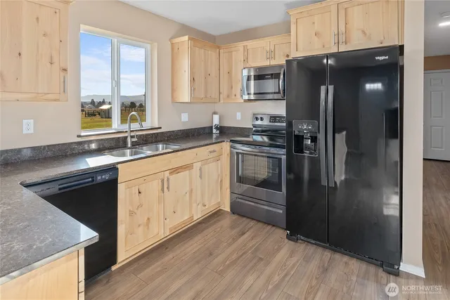 a kitchen with stainless steel appliances granite countertop a refrigerator and a sink