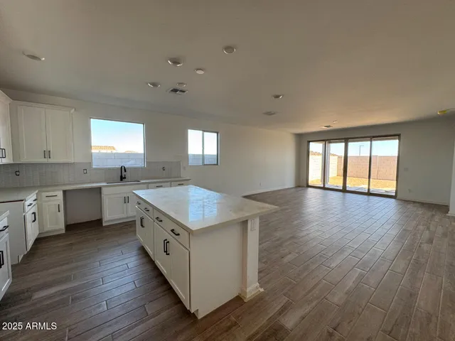 a kitchen with wooden floors and white walls