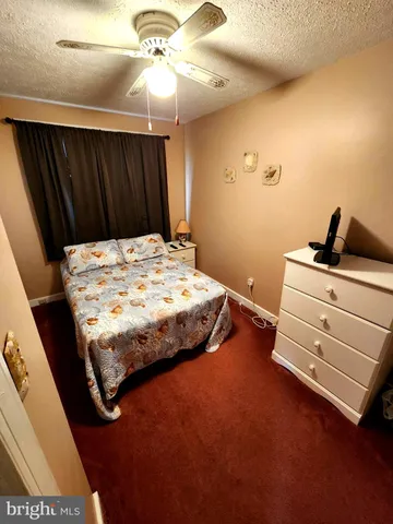 a bedroom with a bed and a ceiling fan