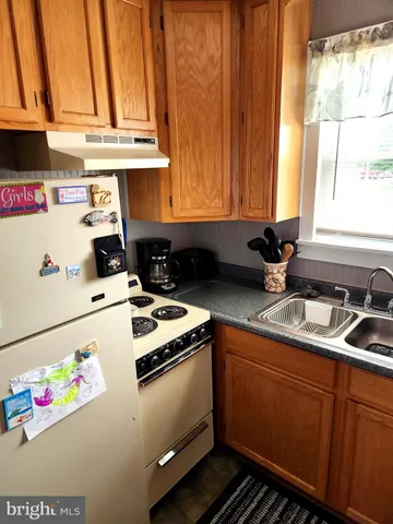 a utility room with fridge and window