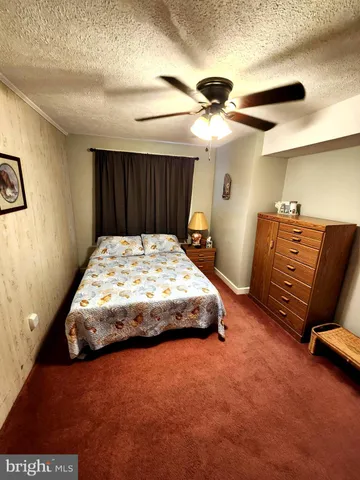 a bedroom with a bed and a ceiling fan