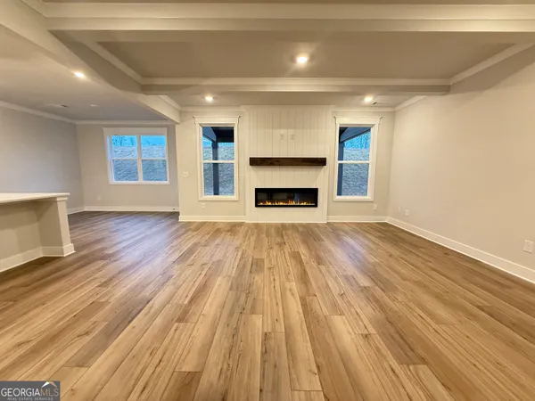 a view of a hallway with wooden floor and stairs