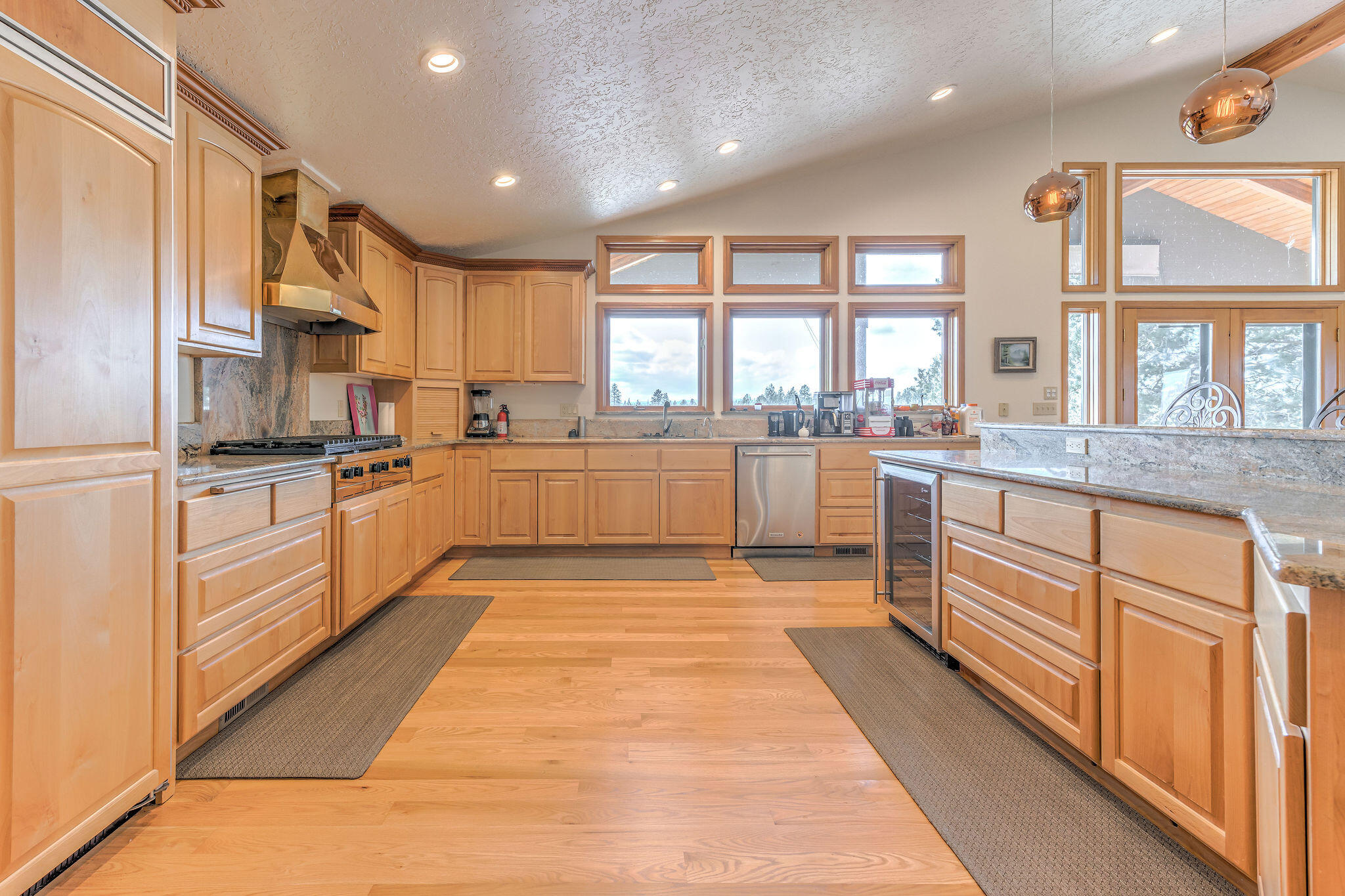 60975 Billadeau Road Bend, OR 97702 - Photo 23 of 65 a large kitchen with stainless steel appliances lots of counter space and windows