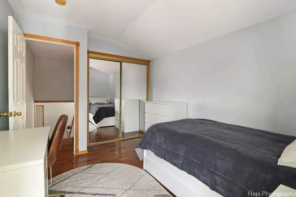 a bedroom with a bed a large window and chair
