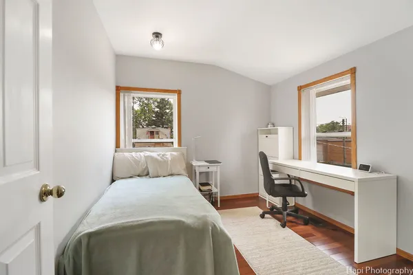 a bedroom with a bed and wooden floor