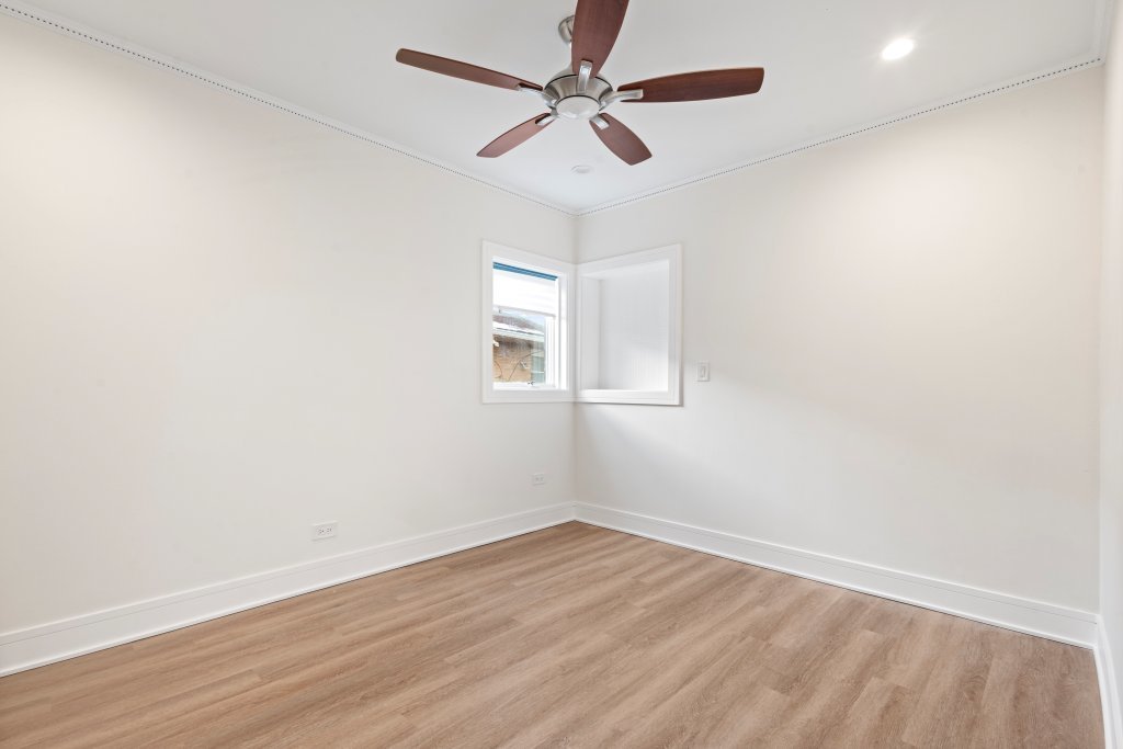 8330 45th Street Lyons, IL 60534 - Photo 17 of 26 an empty room with wooden floor ceiling fan and window
