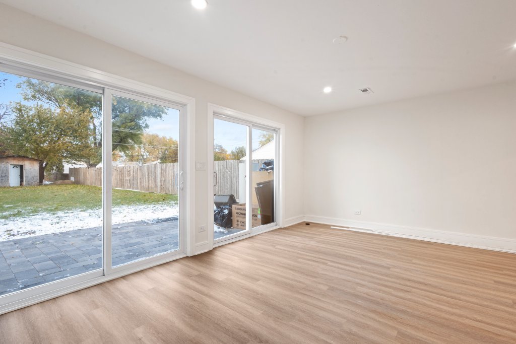 8330 45th Street Lyons, IL 60534 - Photo 3 of 26 a view of an empty room with wooden floor and a floor to ceiling window
