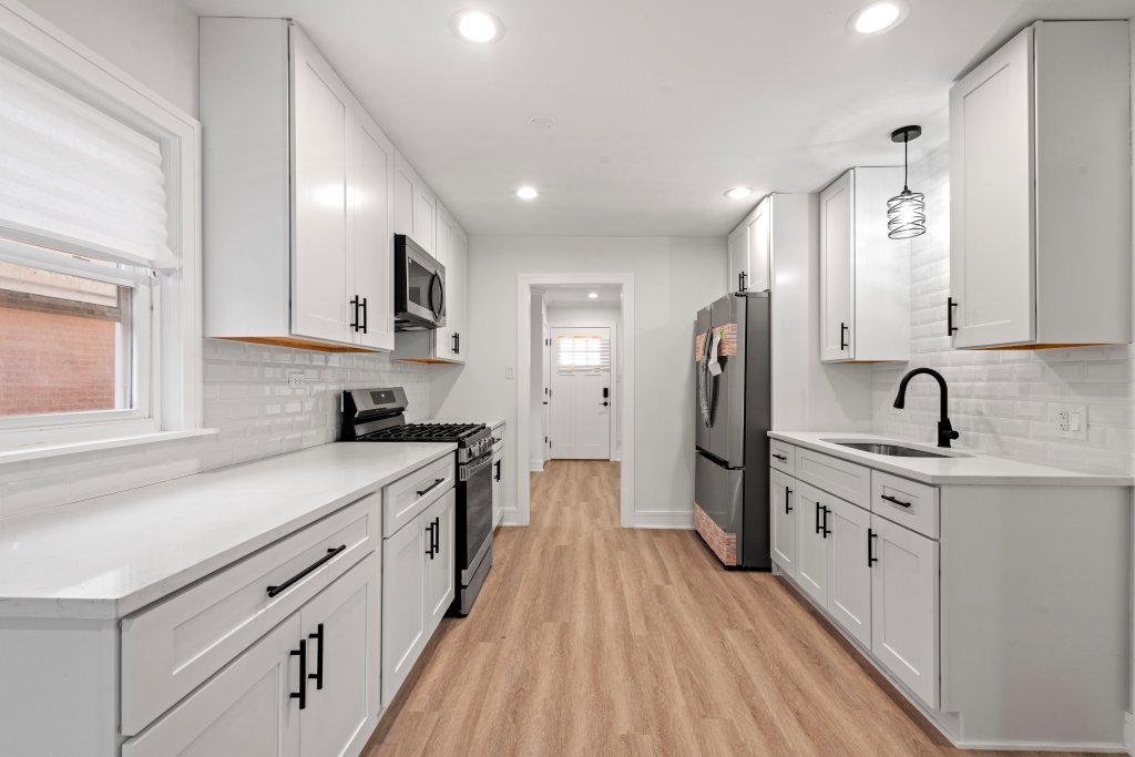 8330 45th Street Lyons, IL 60534 - Photo 8 of 26 a kitchen with white cabinets appliances and sink