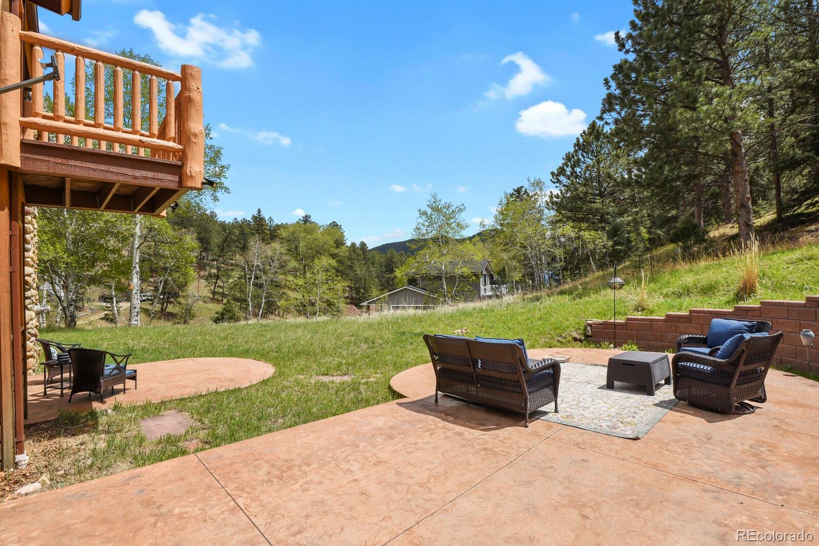 417 Witter Gulch Road Evergreen, CO 80439 - Photo 45 of 50 a view of a patio with couches chairs and a yard