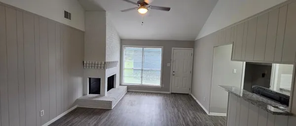 a view of an empty room with a fireplace and a window